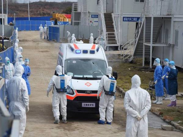 Pekerja perubatan membasmi ambulans yang memindahkan pesakit yang dijangkiti koronavirus di Hospital Huoshenshan di Wuhan. Foto: Xinhua