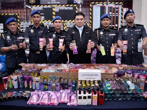 Pengarah Kementerian Perdagangan Dalam Negeri dan Hal Ehwal Pengguna (KPDNHEP) Kuala Lumpur Ariffin Samsudin (tengah) bersama pegawai dan anggotanya menunjukkan sebahagian daripada 5,755 unit barangan tiruan yang terdiri daripada pewangi, losyen dan barang mandian jenama Victoria's Secret bernilai RM100,046 yang dirampas dalam Ops Jeriji pada sidang media hari ini.--fotoBERNAMA