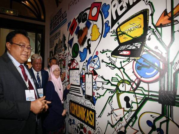 Wan Azizah melakar seni lukis 'Fasih Digital' selepas merasmikan Hari Keselamatan Internet 2020 - Edisi Malaysia hari ini.
Turut hadir, Eddin Syazlee (kiri). Foto: Bernama