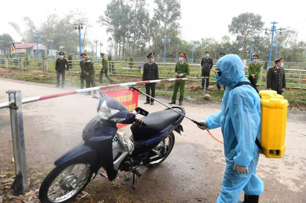 Pihak berkuasa kesihatan melakukan semburan nyahjangkit di pusat pemeriksaan di komuniti Son Loi di wilayah Vinh Phuc hari ini.
- FOTO: AFP