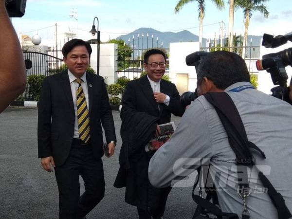 Paul Yong (kiri) bersama Cheok Keng tiba di pekarangan Mahkamah Tinggi Ipoh hari ini.