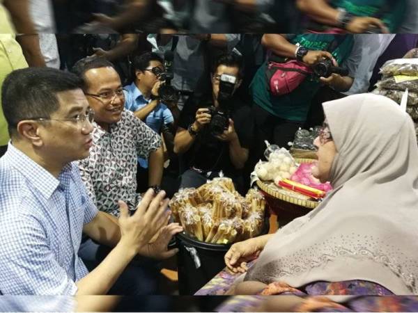 Azmin (kiri) dan Ahmad Samsuri beramah mesra dengan salah seorang peniaga Pasar Payang selepas melakukan tinjauan hari ini.