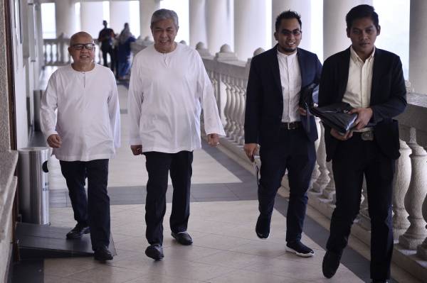 Ahmad Zahid (dua, kiri) ketika hadir pada perbicaraan kesnya di Mahkamah Tinggi hari ini. -Foto Bernama