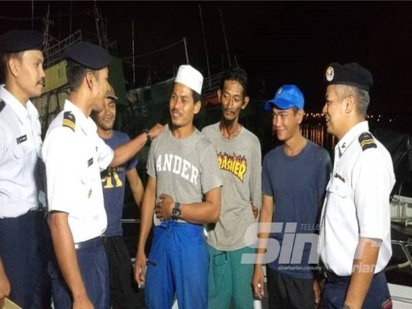 Ariffin (dua dari kiri) bertanya khabar mangsa selepas selamat dibawa ke Jeti Maritim Pulau Kambing di sini kira-kira jam 9 malam tadi.