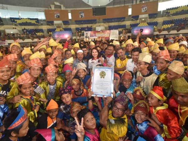 Nurul Fatihah (tengah) menyampaikan pengiktirafan MBOR – The Largest Multilingual Dikir Barat Performance sempena Himpunan Pendikir Muda 2020 di Stadium Tertutup Kompleks Sukan Negeri Terengganu hari ini. - Foto Urusetia Penerangan Darul Iman (UPDI)