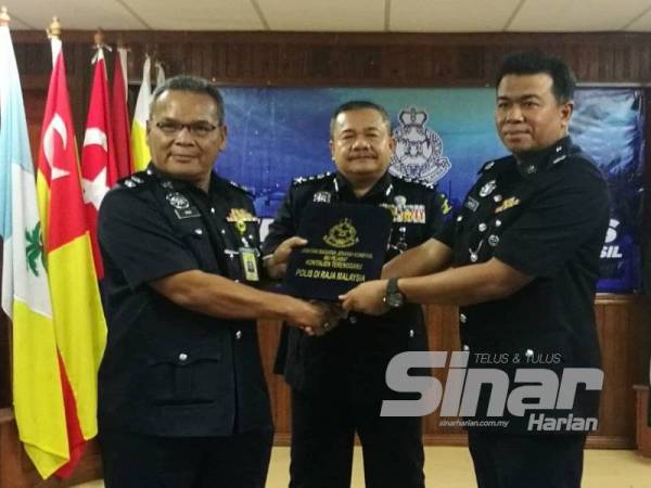 Roslee (tengah) menyaksikan Majlis Serah Terima Tugas Ketua JSJK Terengganu daripada Ketua JSJK Terengganu, Superintendan Mohd Rawi Ab Ghani (kiri) kepada Timbalannya Deputi Superintendan Hamdan Zali (kanan).