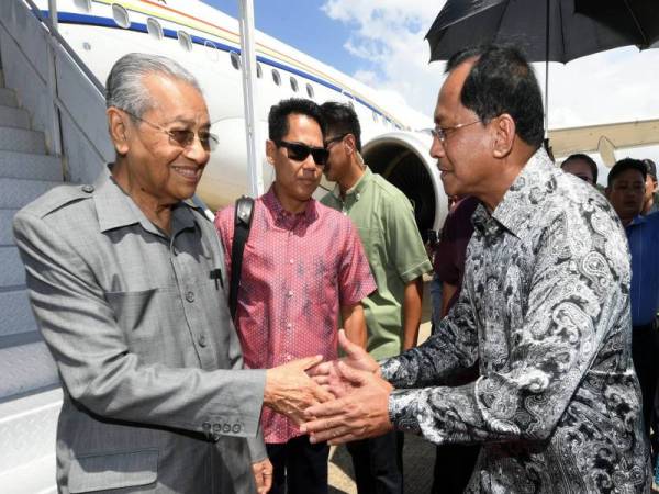 Perdana Menteri, Tun Dr Mahathir Mohamad disambut oleh Timbalan Ketua Menteri Sabah, Datuk Jaujan Sambakong (kanan) sebaik tiba di Terminal 2 Lapangan Terbang Antarabangsa Kota Kinabalu hari ini. - Foto Bernama