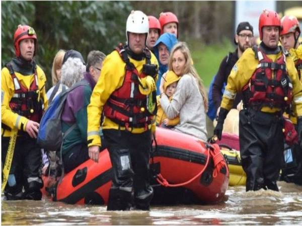 Anggota penyelamat memindahkan penduduk ke pusat kecemasan di Nantgarw berhampiran Cardiff. - FOTO: AGENSI