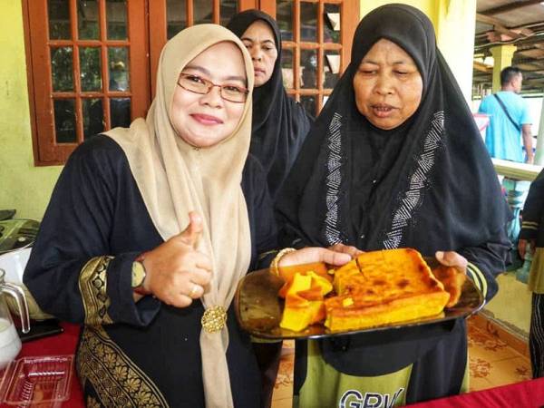 Che Esah (kanan) menunjukkan bingka sawit hasil resipinya.