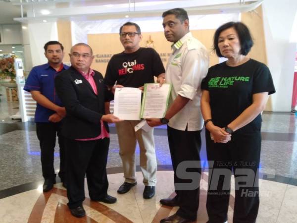 Abdul Razak (tiga dari kanan) bersama Saha (dua dari kanan) menyerahkan memorandum kepada Mohd Ridzuwan di lobi SUK hari ini. 