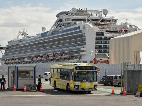 Sebuah bas membawa kumpulan penumpang yang dibawa turun dari kapal pesiaran Diamond Princess meninggalkan Terminal Daikoku Pier Cruise di Yokohama.