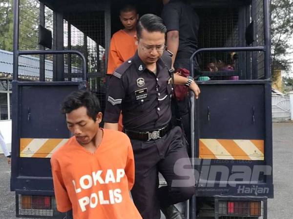 Junianto (depan) didakwa di Mahkamah Majistret Dungun hari ini kerana membunuh rakan sekerjanya.