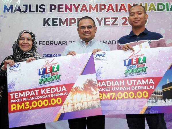 Ahmad Shukri (tengah) menyampaikan hadiah utama kempen YEZ 2019 kepada dua pemenang iaitu Mohd Izdham Mohd Nasir (kanan) dan Noorlina Mohd Rashid.