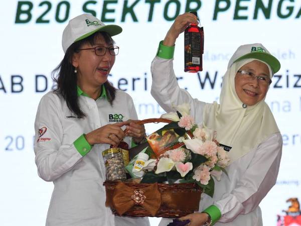 Dr Wan Azizah (kanan) menerima cenderahati daripada Teresa pada Pelancaran Program Biodiesel B20 Sektor Pengangkutan di Dataran Merdeka hari ini. - Foto Bernama