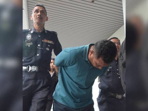 Mohd Narshidi diiringi polis ketika dibawa ke Mahkamah Majistret Ayer Keroh hari ini.