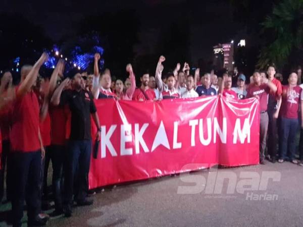 Ahli Armada Bersatu memegang kain rentang sambil melaungkan kekal Tun M di hadapan Yayasan Kepimpinan Perdana di sini malam ini. 