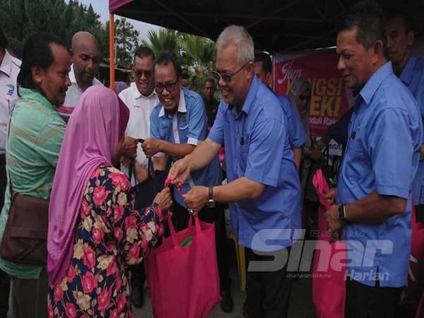 Ishak (dua,kanan) dan Sofi (tiga,kanan) menyampaikan sumbangan kepada penerima kepada program Bazar Peduli Rakyat di pekarangan Kompleks JAPERUN Durian Tunggal di sini, hari ini.	