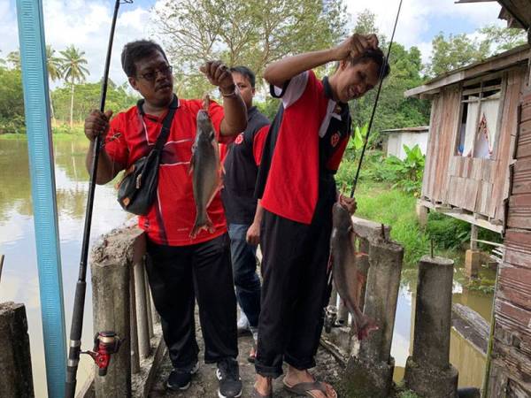 Dua peserta OKU cacat penglihatan menunjukkan hasil tangkapan mereka pada program memancing belia OKU penglihatan hari ini.