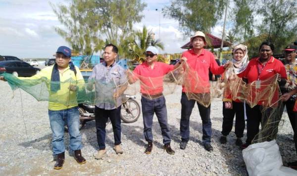 Abdul Rahman (tengah) menunjukkan bubu naga yang dijumpai sekitar tukun kelong di Pantai BNO sempena program Save Our Sea hari ini.