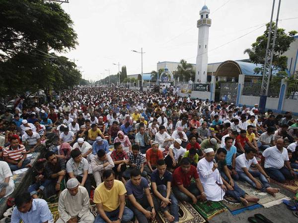 Penduduk beragama Islam menunaikan solat Aidilfitri di luar Masjid Biru di Taguig, Metro Manila.