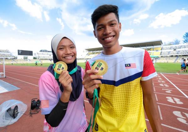 Azeem (kanan) dan Nurul Wardatul bersama pingat dimenangi masing-masing pada kejohanan di Stadium Perak. <GAMBAR DALAM>
