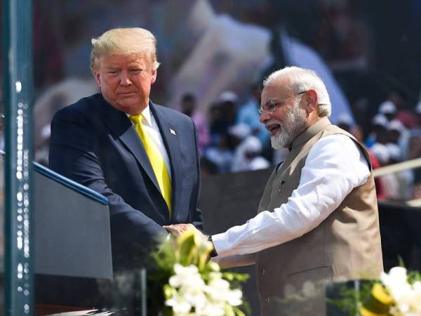 Trump (kiri) berjabat tangan dengan Modi di Stadium Sardar Patel di Motera, Ahmedabad, India hari ini. - Foto AFP