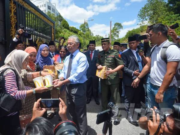 Yang di Pertuan Agong, Al Sultan Abdullah Ri'ayatuddin Al-Mustafa Billah Shah mencemar duli menyampaikan makanan tengah hari kepada petugas-petugas media di luar Istana Negara hari ini. -Foto SHARIFUDIN ABDUL RAHIM