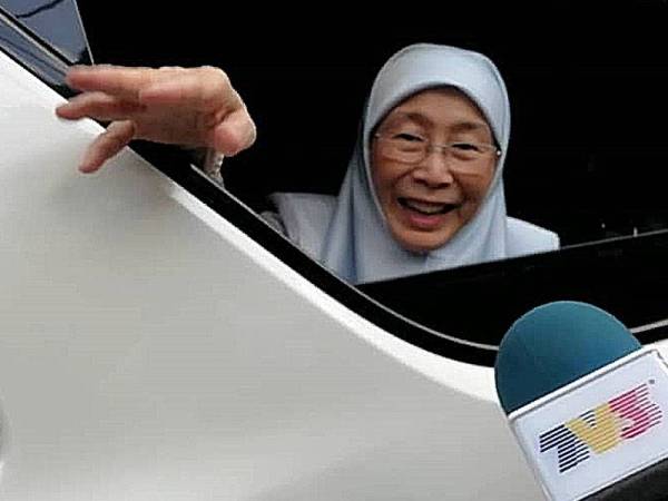 Wan Azizah menyapa media yang membuat liputan di pekarangan rumahnya sejak pagi tadi.