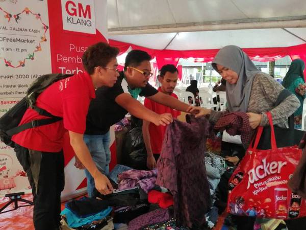 Urusetia membantu pengunjung mendapatkan barangan preloved yang disediakan sempena Karnival Jalinan Kasih ECO Free Market di Projek Perumahan Rakyat (PPR) Seri Pantai.