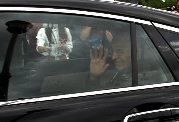 Perdana Menteri Interim Tun Dr Mahathir Mohamad melambai tangan kepada pemberita sebaik keluar dari Bangunan Perdana Putra semalam. -Foto Bernama