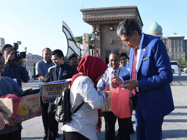 PUTRAJAYA - Timbalan Ketua Setiausaha Jabatan Perdana Menteri Datuk Mohd Sallehhuddin Hassan menyempaikan sarapan pagi kepada para pemberita yang menunggu di luar bangunan Perdana Putra hari ini. - Foto BERNAMA 