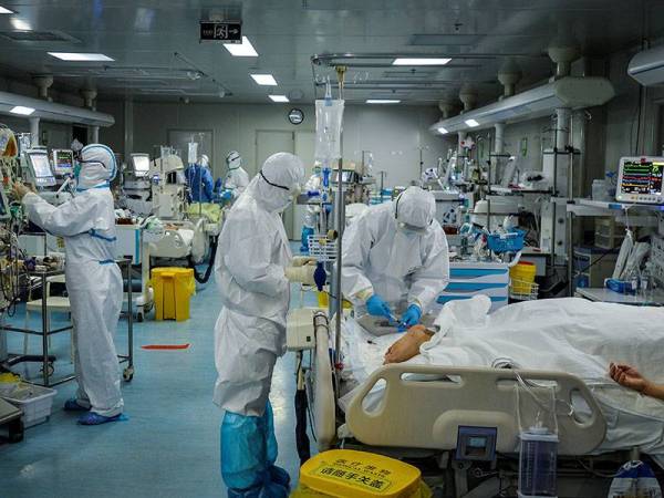 Kakitangan perubatan merawat pesakit dijangkiti Covid-19 di sebuah hospital di Wuhan. - Foto AFP