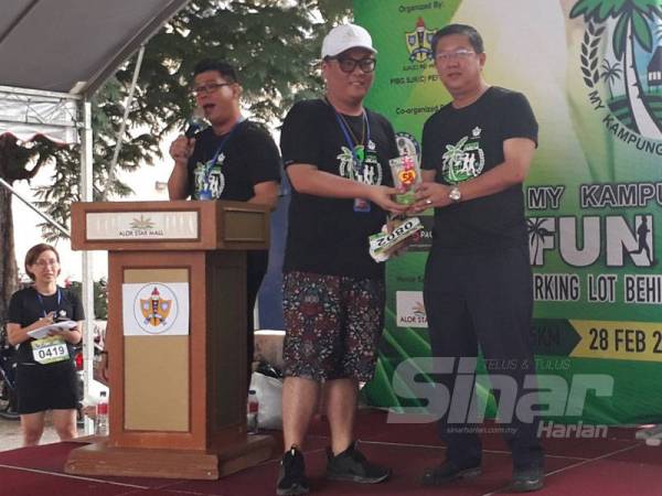 Kok Yew (kanan) menyampaikan hadiah cabutan bertuah kepada peserta My Kampung Fun Run 2020 di pekarangan Alor Setar Mall hari ini. 