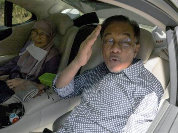 Anwar bersama Dr Wan Azizah dilihat keluar dari kediaman mereka menuju ke Hotel Eastin dipercayai bagi menghadiri mesyuarat Pakatan Harapan hari ini.  - Foto Bernama