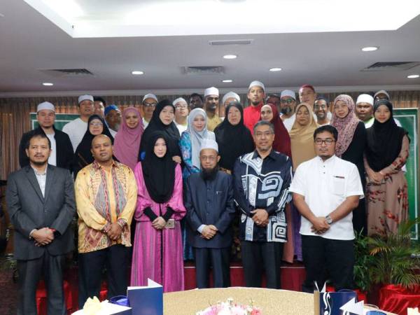 Mohamed Rafik (dua dari kanan) merakamkan gambar bersama pendakwah mualaf yang terpilih menerima pakej umrah di Grand Bluewave Hotel, Shah Alam kelmarin.