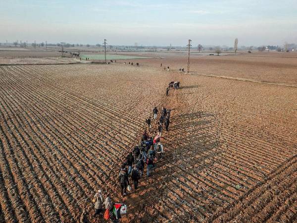 Kumpulan migran berjalan di sepanjang sempadan Turki-Greece berhampiran Pazarkule di daerah Edirne semalam. - Foto AFP