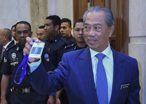 Tan Sri Muhyiddin Yassin menunjukkan pas Jabatan Perdana Menteri miliknya pada hari pertama beliau memulakan tugas sebagai Perdana Menteri kelapan di Bangunan Perdana Putra hari ini. -Foto Bernama