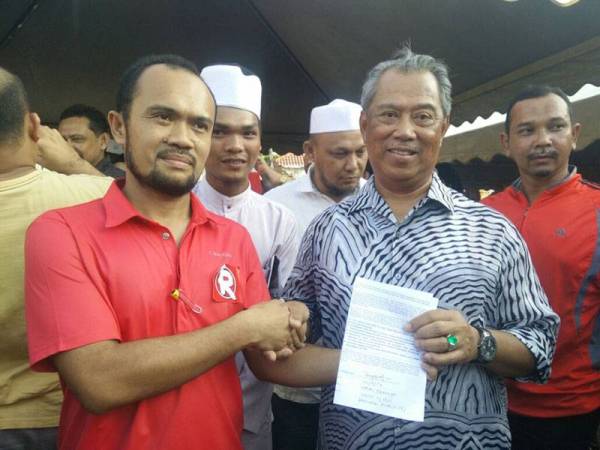 Nazri (kiri) menyerahkan memorandum tuntutan royalti kepada Muhyiddin ketika beliau melawat negeri Kelantan pada tahun 2016.