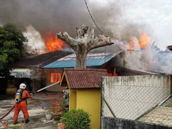 Bomba menjalankan operasi memadam kebakaran membabitkan dua rumah di Jalan Pasar, Teluk Intan pagi tadi. - Foto JBPM Perak