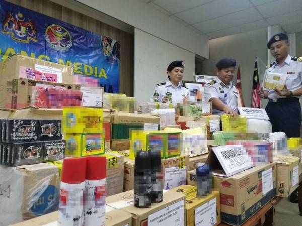 Rosli (tengah) menunjukkan antara barang yang dirampas susulan penahanan sebuah bot barter trade di 0.2 batu nautika Pelabuhan Barat Klang, kelmarin.