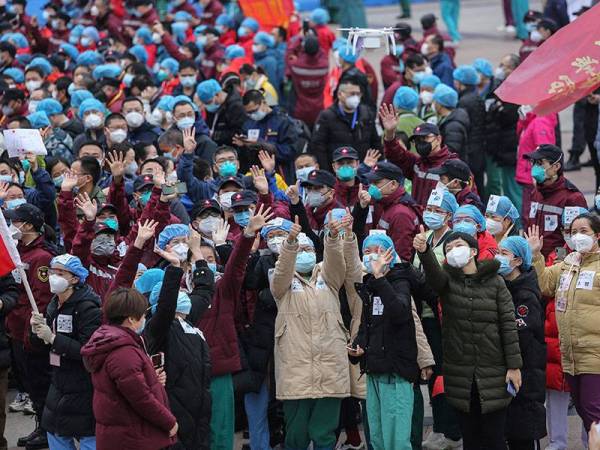 Kakitangan perubatan meraikan ‘kejayaan’ mereka selepas kesemua pesakit dibenarkan keluar dari hospital sementara di Wuhan, wilayah Hubei hari ini. - Foto AFP