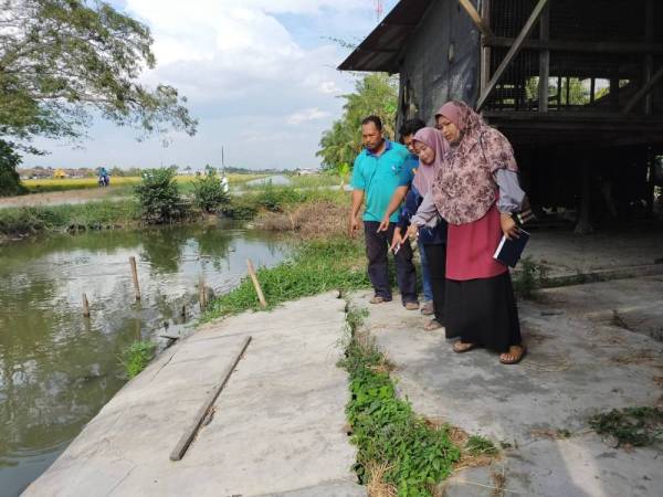 Ahli keluarga Abdul Hamid menunjukkan kesan hakisan yang menyebabkan lantai di kawasan kandang mereka mendap dan retak.