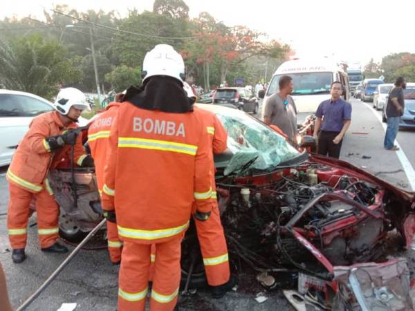 Anggota bomba menjalankan operasi mengeluarkan mangsa yang tersepit dalam nahas dua kenderaan. - Foto JBPM Perak