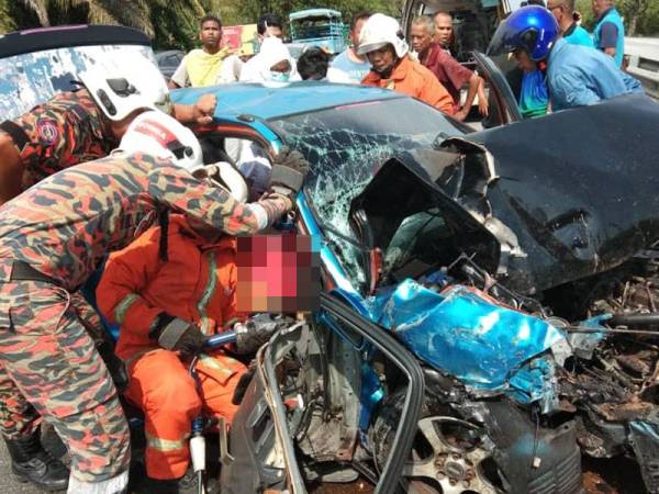 Anggota bomba mengeluarkan mayat mangsa. - Foto PDRM