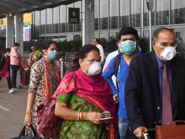 Orang ramai memakai topeng muka sebagai langkah pencegahan terhadap penyebaran wabak Covid-19. Foto: AFP