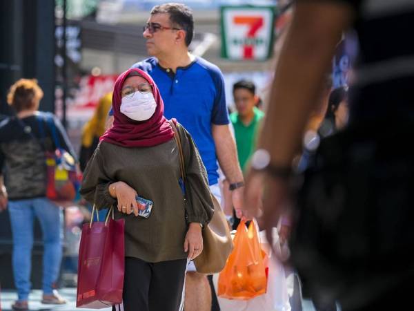 Seorang wanita memakai penutup hidung dan mulut bagi mengelak jangkitan virus di Bukit Bintang. - Foto 123RF