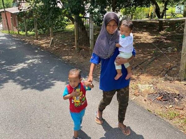 Nur Azlinah sedang berjalan kaki bersama anaknya berusia 3 tahun dan 9 bulan untuk ke klinik desa bagi mendapatkan rawatan untuk anaknya.