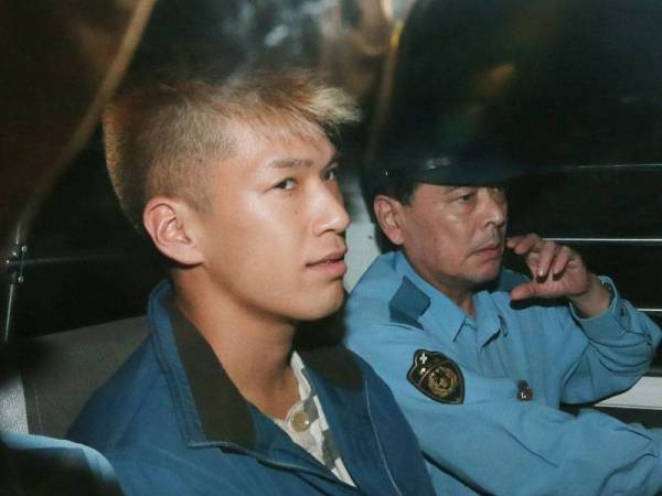 Satoshi Uematsu (kiri) dibawa ke balai polis di Tsukui, wilayah Kanagawa, Jepun empat tahun lalu. - Foto AFP