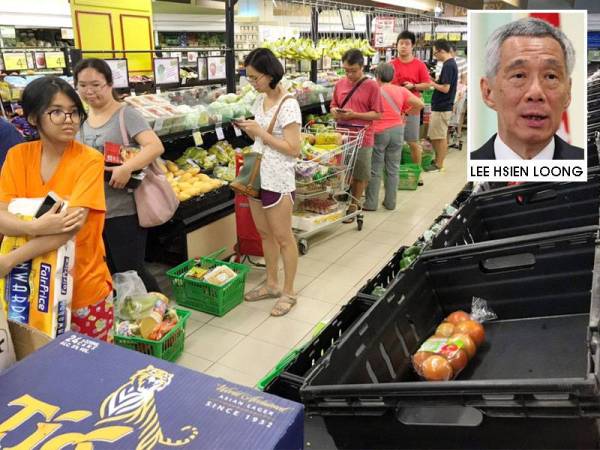 Pengguna di Singapura mendapatkan barang keperluan mereka di sebuah pasar raya di Singapura semalam. Gambar kecil: Lee Hsien Loong. - FOTO: AGENSI