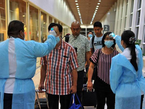 Kakitangan Jabatan Kesihatan Negeri Wilayah Persekutuan Labuan giat mempertingkatkan usaha saringan kesihatan kepada para penumpang yang tiba di terminal Lapangan Terbang Labuan sebagai langkah berjaga-jaga bagi mencegah penularan Covid-19 ketika tinjauan semalam. - Foto Bernama